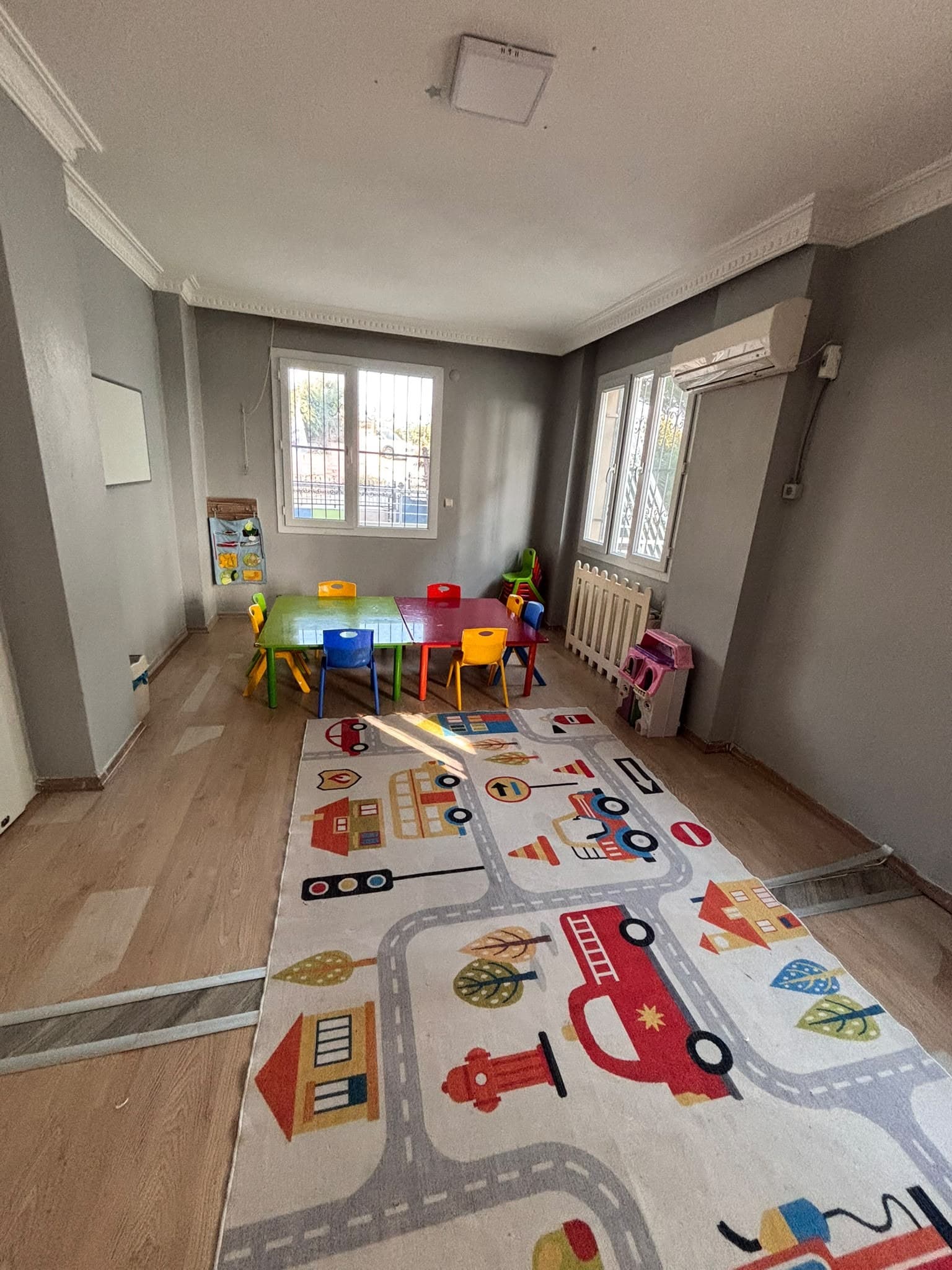 Pencereden gün ışığı alan sınıf ve trafik temalı oyun halısı